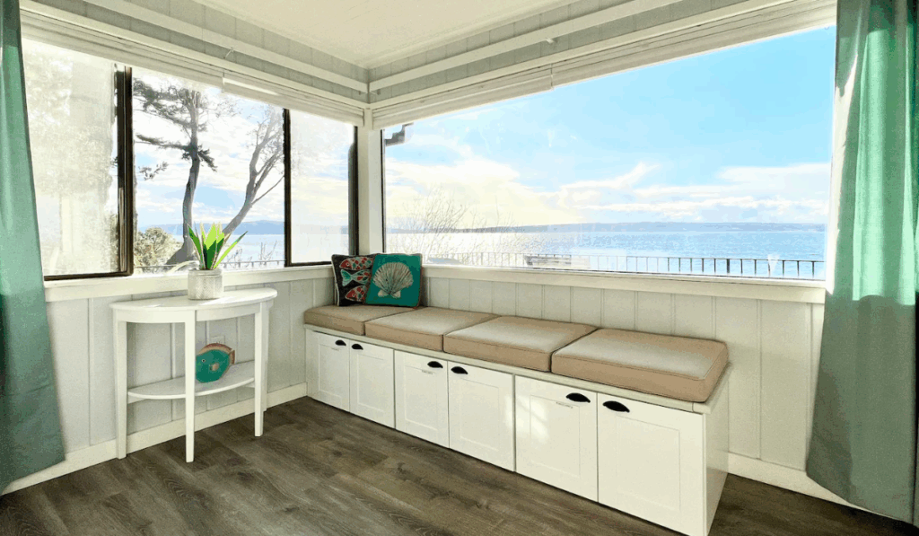 Bright corner room with large windows offering an ocean view and built-in bench seating