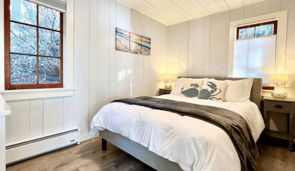 Cozy bedroom with a double bed, large window, and soft white decor